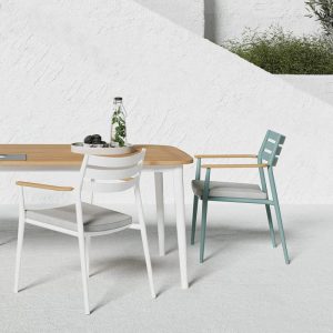 Ein weißer und ein hellgrüner Stuhl mit Teakarmlehnen und ein Tisch mit einer Tischplatte aus Teakholz